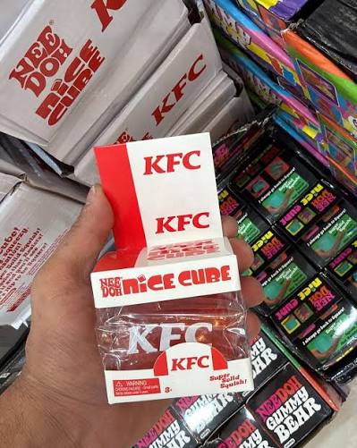 Hand holding a boxed KFC NeeDoh squishy in a toy shop