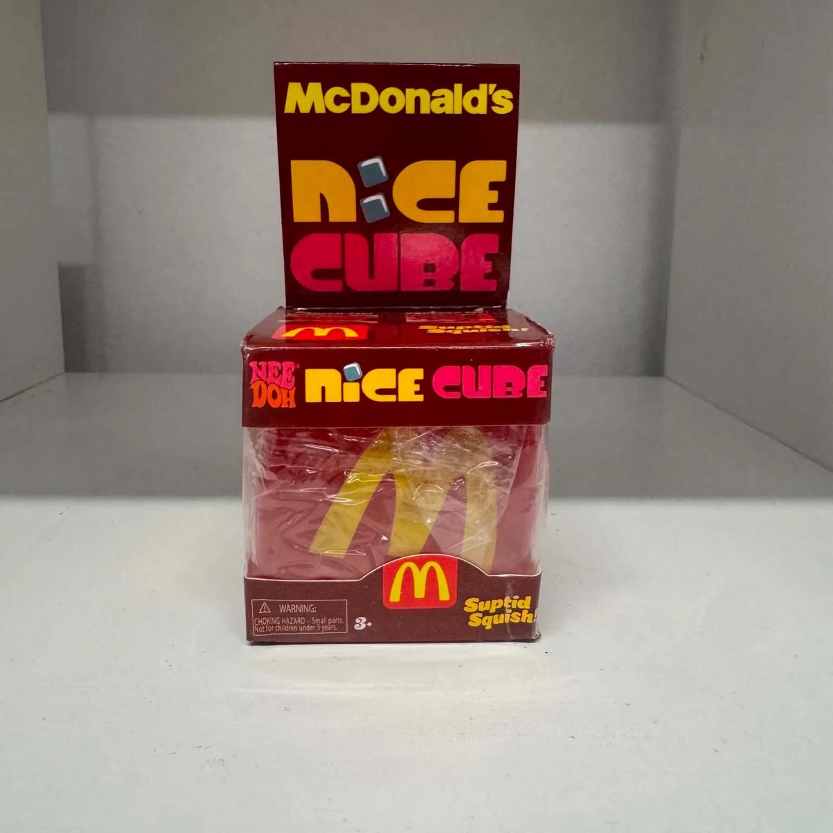 Dark red McDonald's Nice Cube carton with the arches cube sealed inside